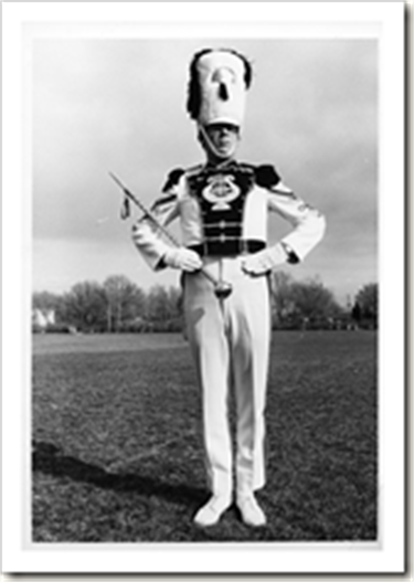 A black and white photo of a marching band Drum Major.