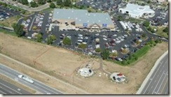 An aerial overhead view of a car dealership showing a parking lot filled with cars.